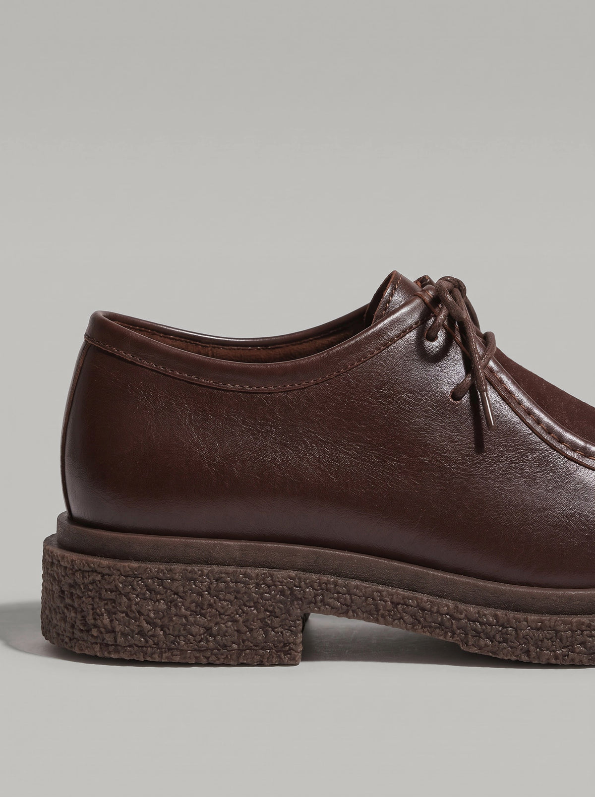 Lucca Dark Brown - נעל שרוכים מעור בחום כהה עם תפר מוקסין בולט סביב החזית וסוליה עבה בעלת טקסטורה.