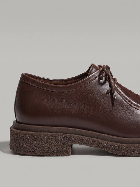 Lucca Dark Brown - נעל שרוכים מעור בחום כהה עם תפר מוקסין בולט סביב החזית וסוליה עבה בעלת טקסטורה.