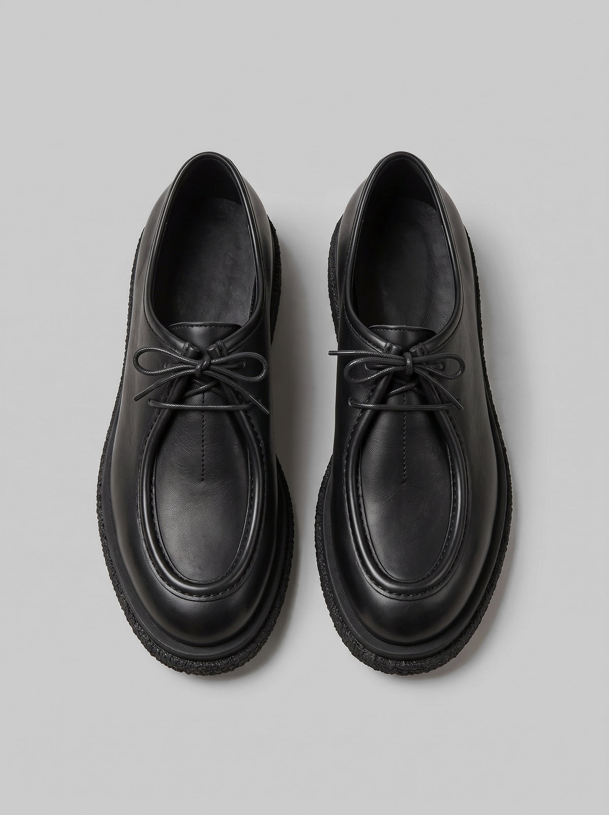 Lucca Black - נעל שרוכים מעור שחור עם תפר מוקסין בולט סביב החזית וסוליה עבה בעלת טקסטורה.