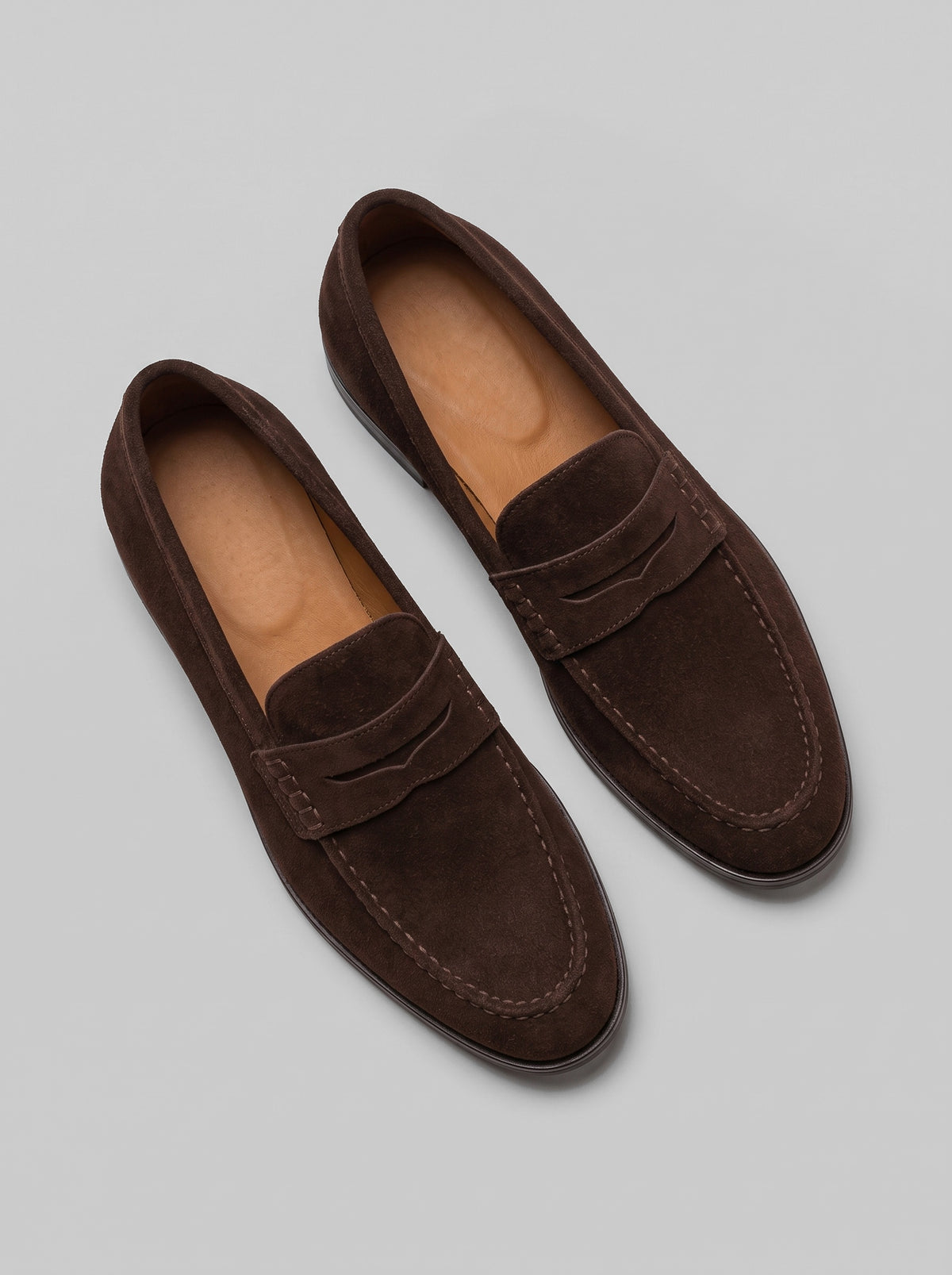 Ravenna Dark Brown - מוקסין זמש בחום כהה עם רצועה מעוטרת בתפרים מעל החזית, תפר מוקסין סביב החרטום וסוליה שטוחה.