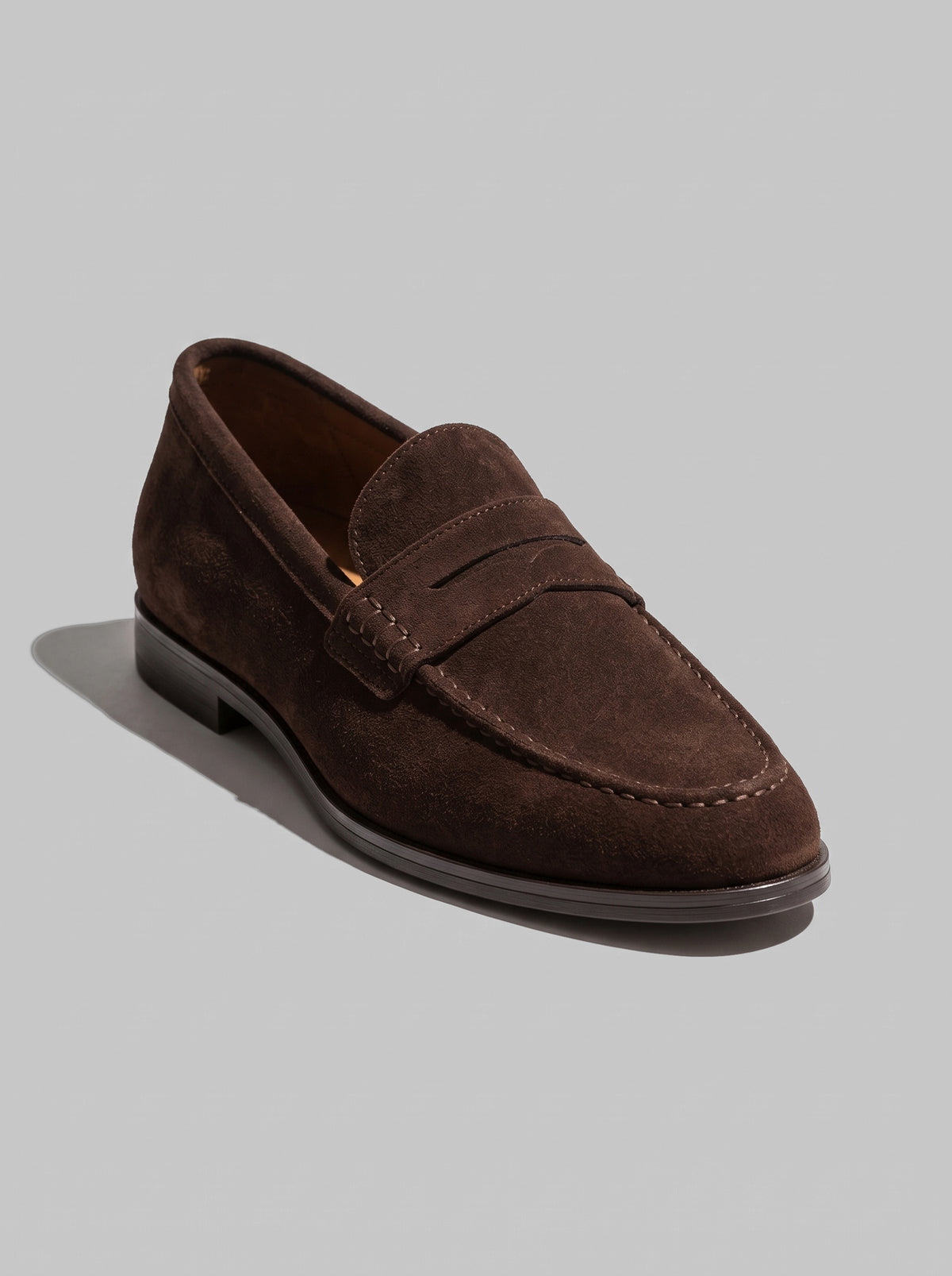 Ravenna Dark Brown - מוקסין זמש בחום כהה עם רצועה מעוטרת בתפרים מעל החזית, תפר מוקסין סביב החרטום וסוליה שטוחה.