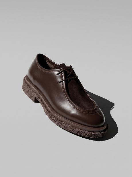 Lucca Dark Brown - נעל שרוכים מעור בחום כהה עם תפר מוקסין בולט סביב החזית וסוליה עבה בעלת טקסטורה.